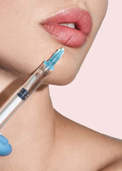 Die vollen Lippen einer jungen Frau, die eine Injektion mit Hyaluronsäure erhält.